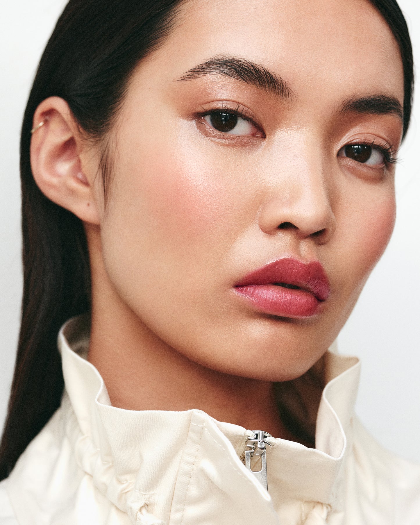 Close-up of a woman wearing the Manasi 7 Kuranberi All over Colour on her eyes, lips and cheeks with a neutral background