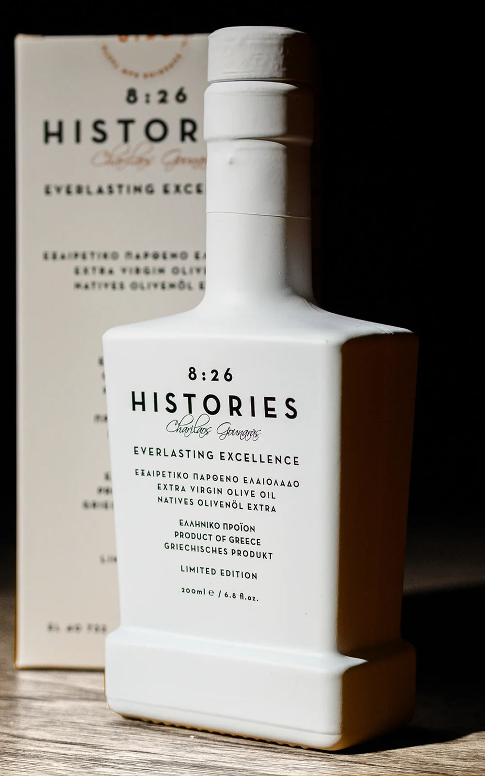 Bottle of 8:26 Histories olive oil on a wooden surface with a dark background