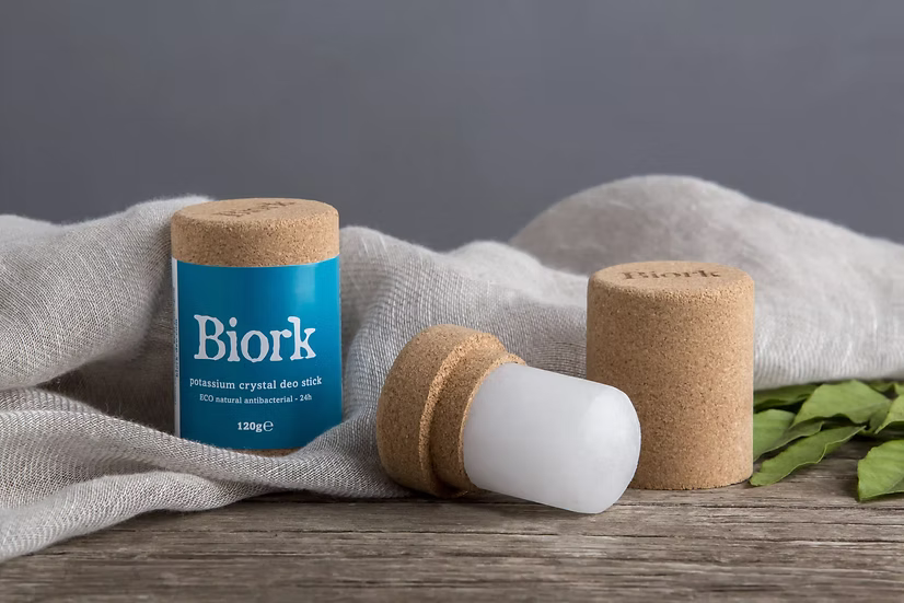 Biork premium crystal deo stick with cork cap on a wooden surface with a gray background