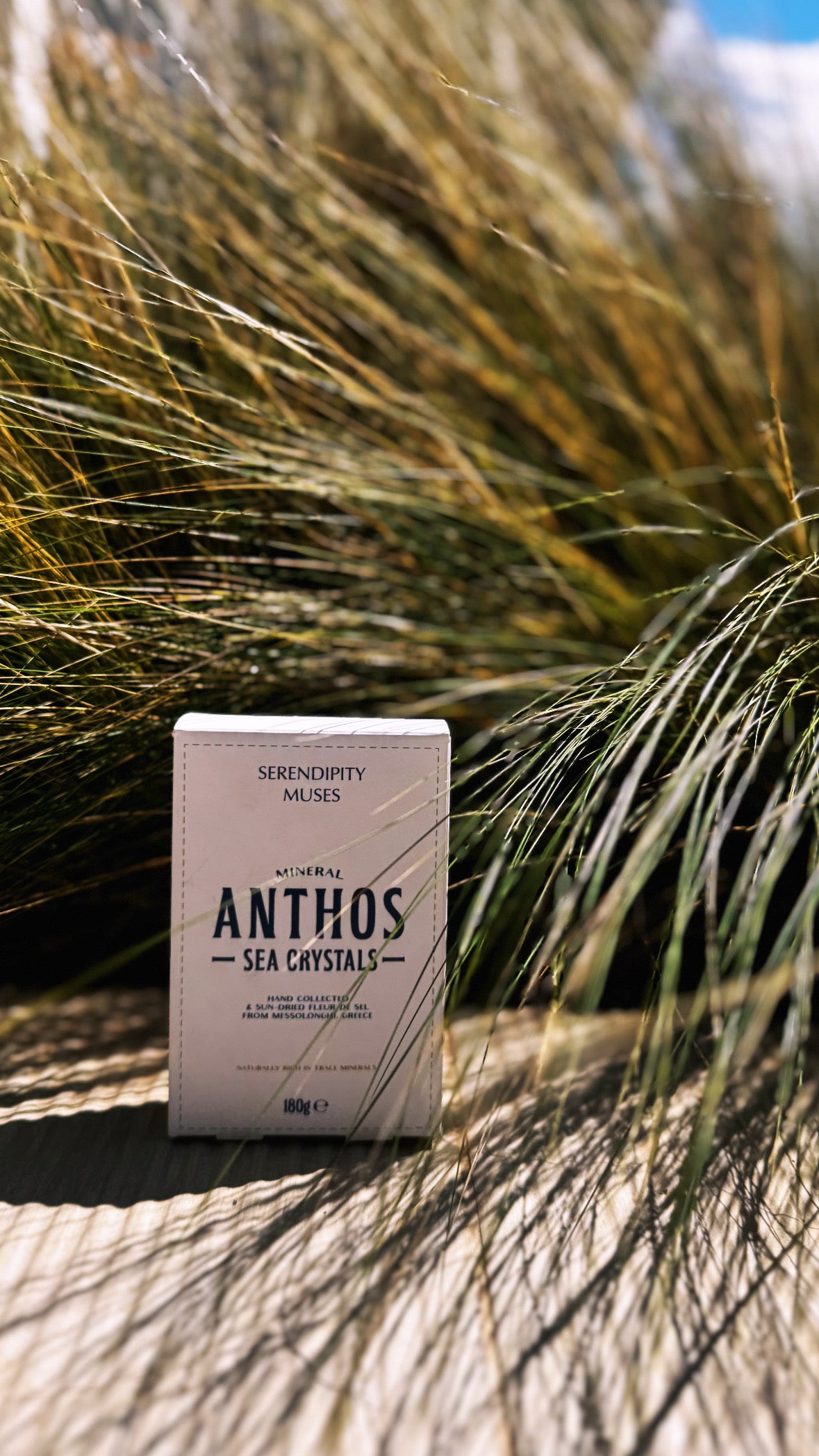 Box of Anthos Mineral Sea Crystals in a natural setting with grasses.