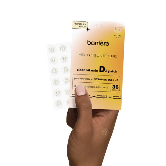 Barriere vitamin D3 patch packaging with the gold sun symbol held by a hand on a white background