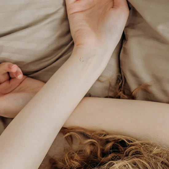 Close-up of a person wearing the Barriere melatonin patches with gold moon symbols 