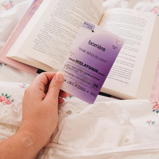 Barrière Melatonin patch held over an open book on a floral blanket