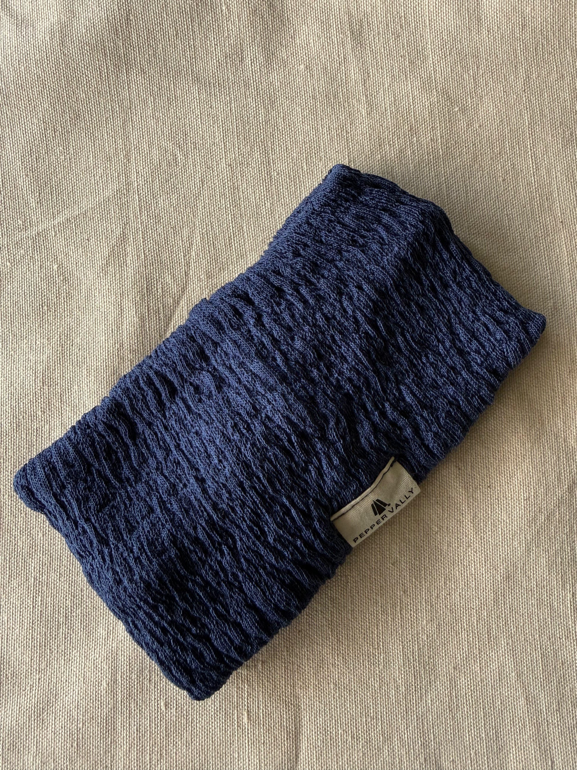 Blue knitted headband on a beige fabric background
