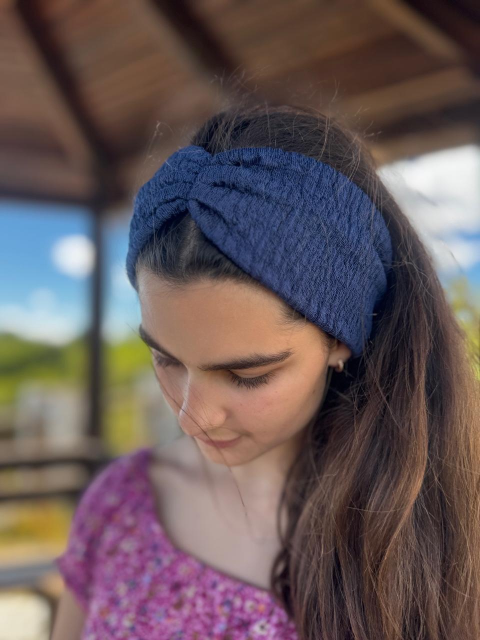 Woman wearing a blue knitted headband outdoors