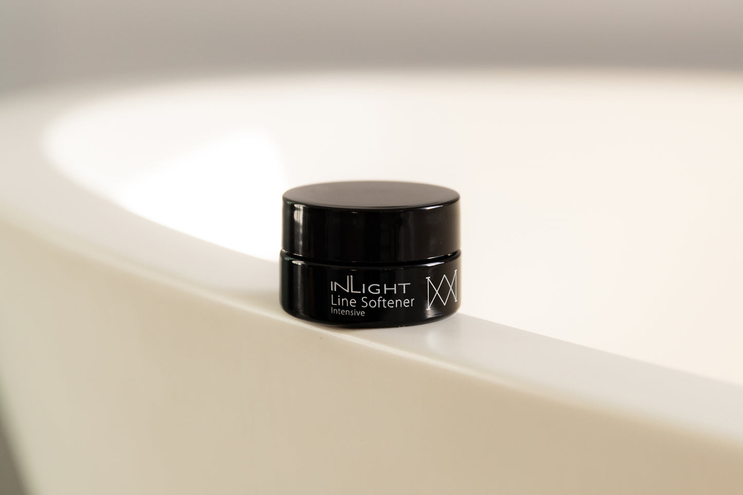 A jar of the Inlight Line Softener Intensive on a bathtub