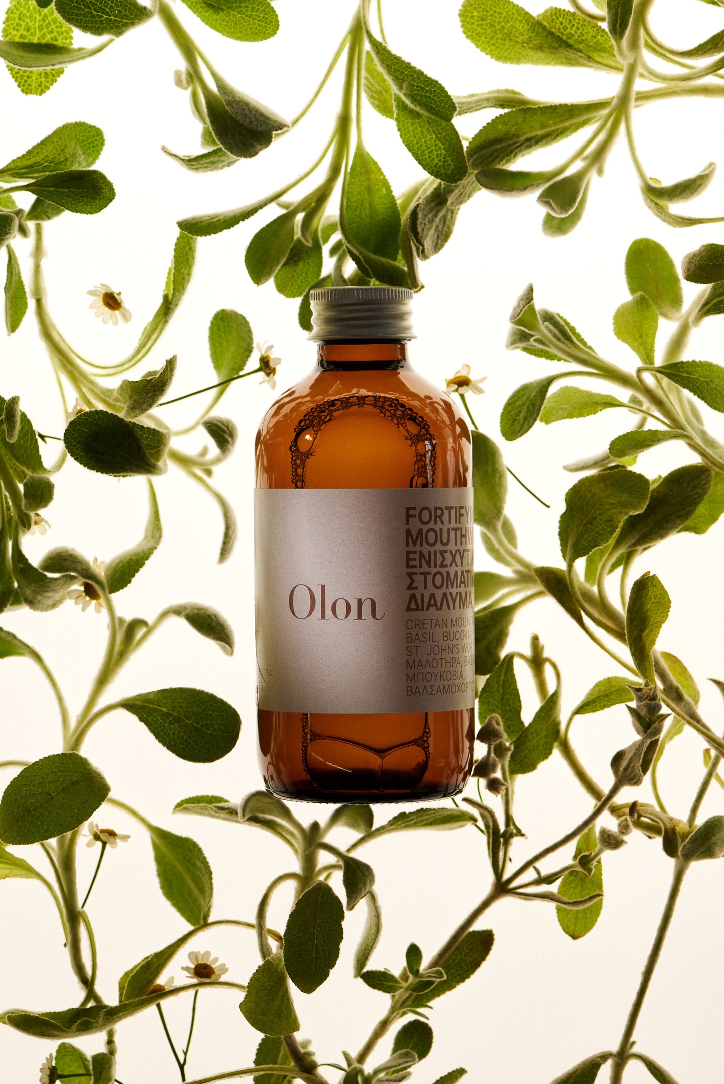 the bottle of the Fortifying Mouthwash by Olon with plants on the background