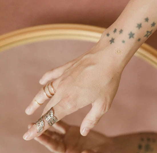 Close-up of a person wearing the Barriere vitamin D3 patch packaging with sun symbol design on their arm