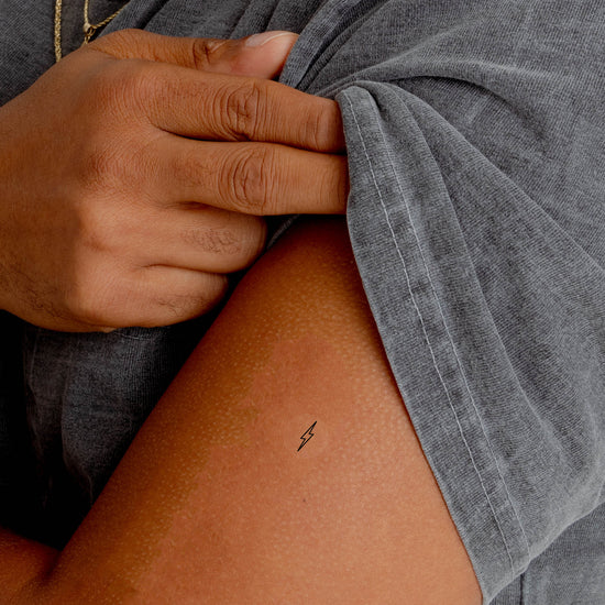 Close-up of a person wearing the Barriere Energy Boost vitamin B12 patch with the black bolt symbol on their arm