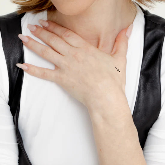 Close-up of a person wearing the Barriere Energy Boost vitamin B12 patch with the black bolt symbol on their hand