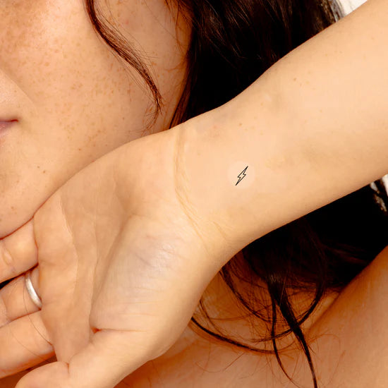 Close-up of a person wearing the Barriere Energy Boost vitamin B12 patch with the black bolt symbol on their wrist