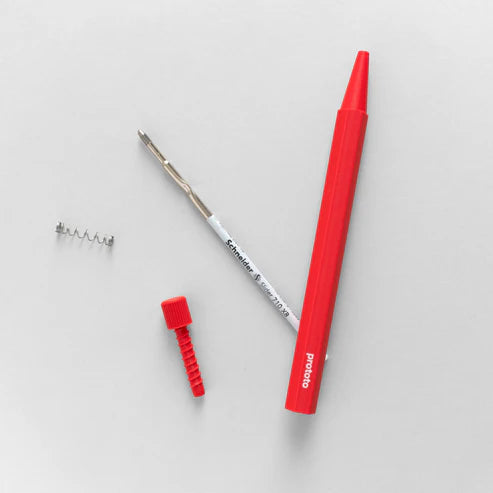 Red prototo pen and its parts on a grey background
