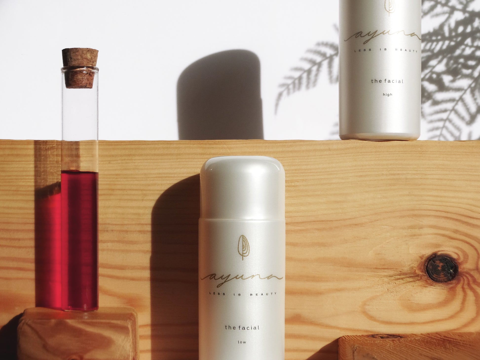 Cosmetic bottles of 'ayuna' the facial - low branding on a wooden surface