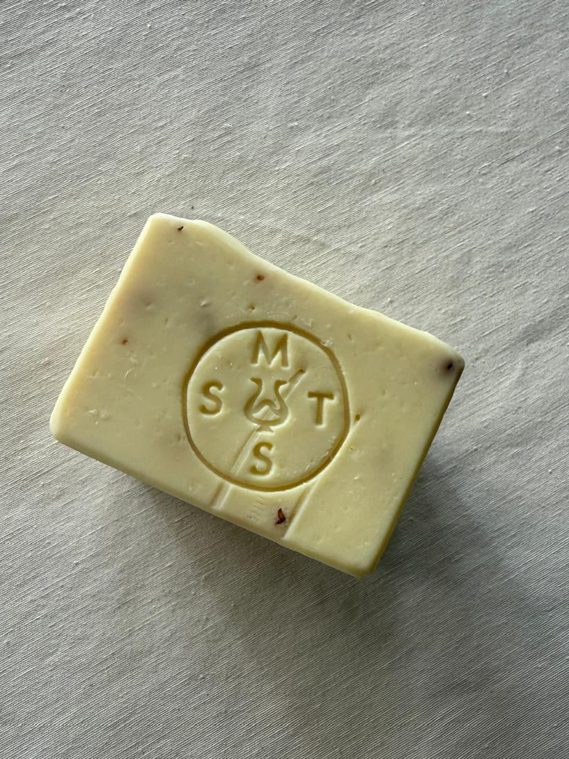 Bar of lavender soap with the Serendipity Muses logo on a white surface 
