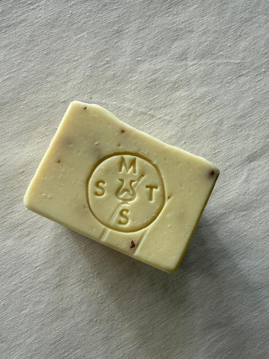 Bar of lavender soap with the Serendipity Muses logo on a white surface 