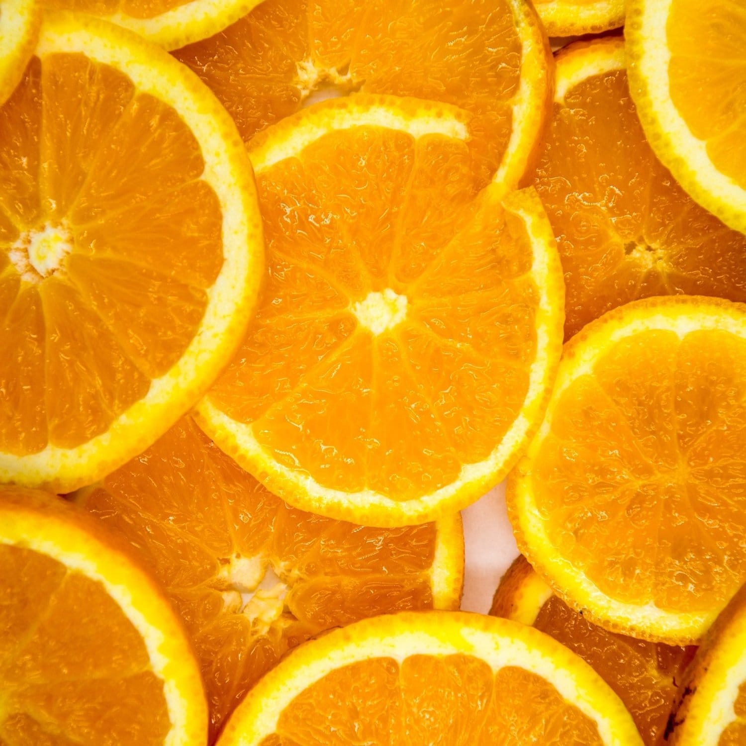 Close-up of sliced oranges with a bright orange background