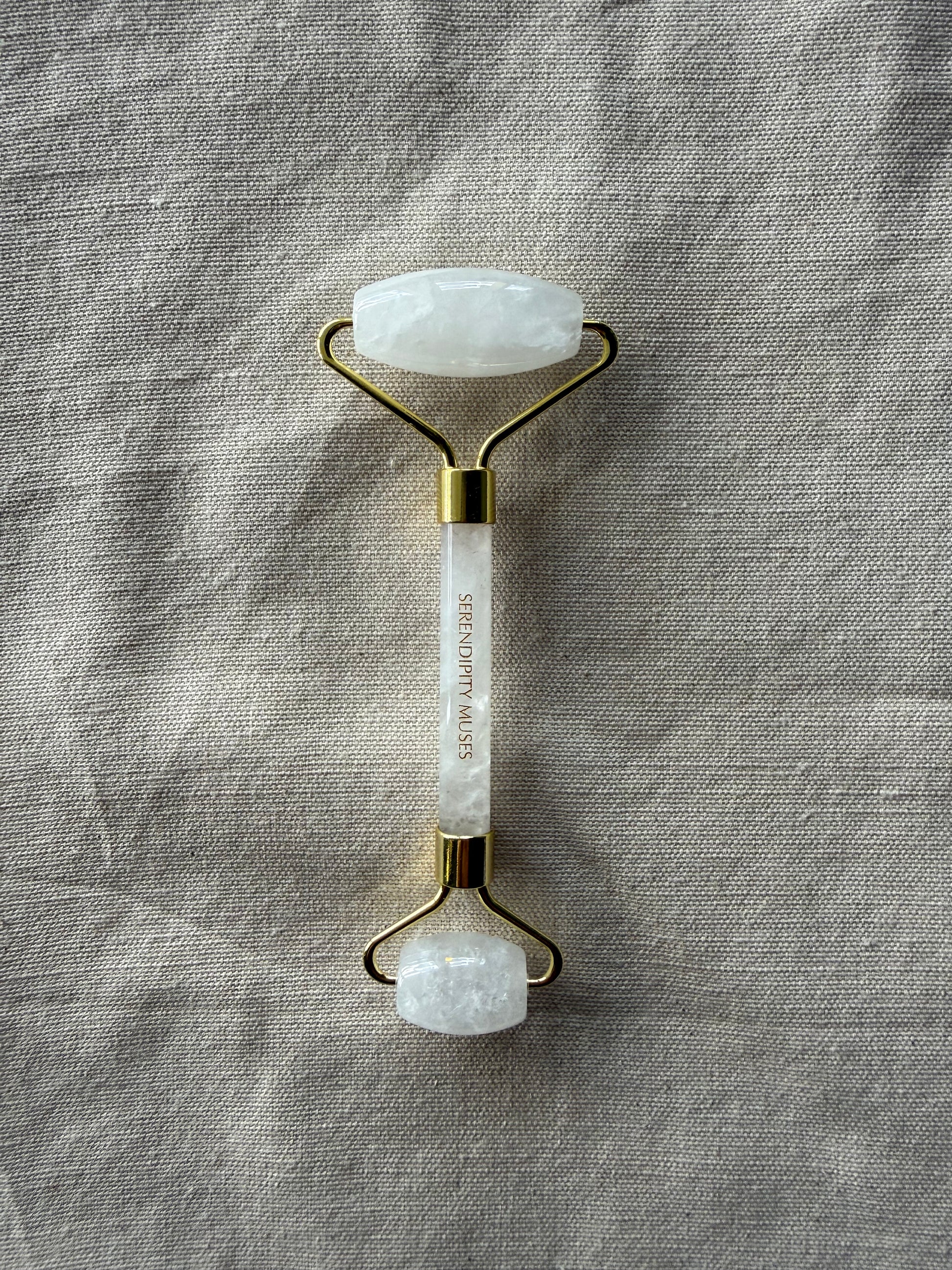 White Jade Facial Roller with gold Serendipity Muses logo on a white background