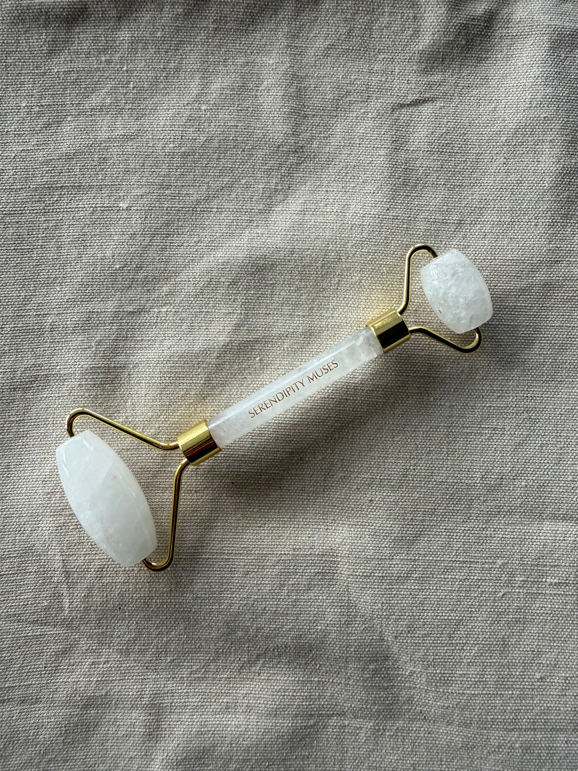 White Jade Facial Roller with gold Serendipity Muses logo on a white background