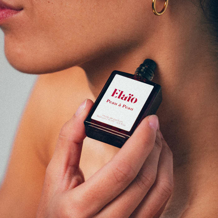 Elaio Peau à Peau perfume oil roll-on bottle against a soft background.