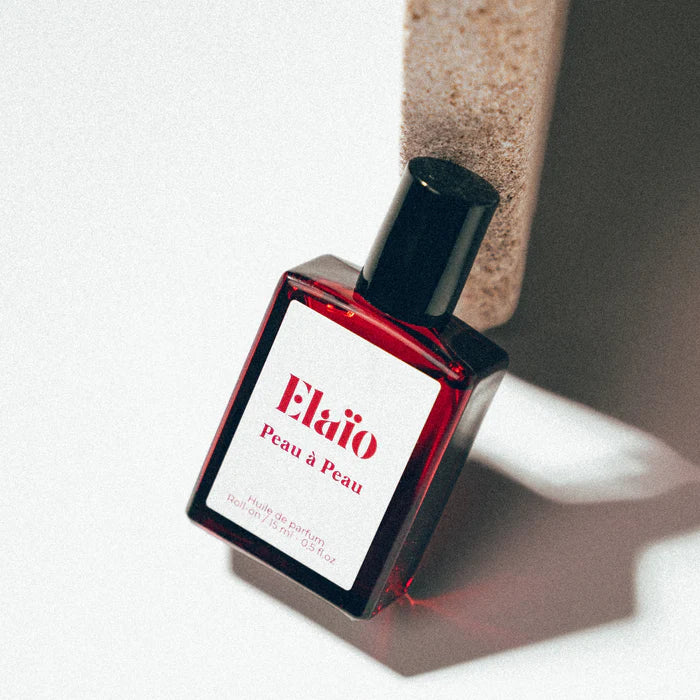 Elaio Peau à Peau perfume oil roll-on bottle against a soft background.