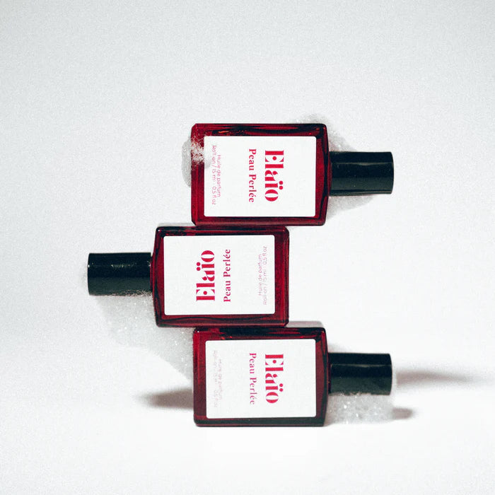 Three Elaéo Peau Perlée perfume bottles with white labels on a white background