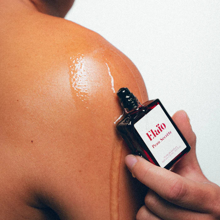 Peau Secrète perfume oil roll-on bottle on skin