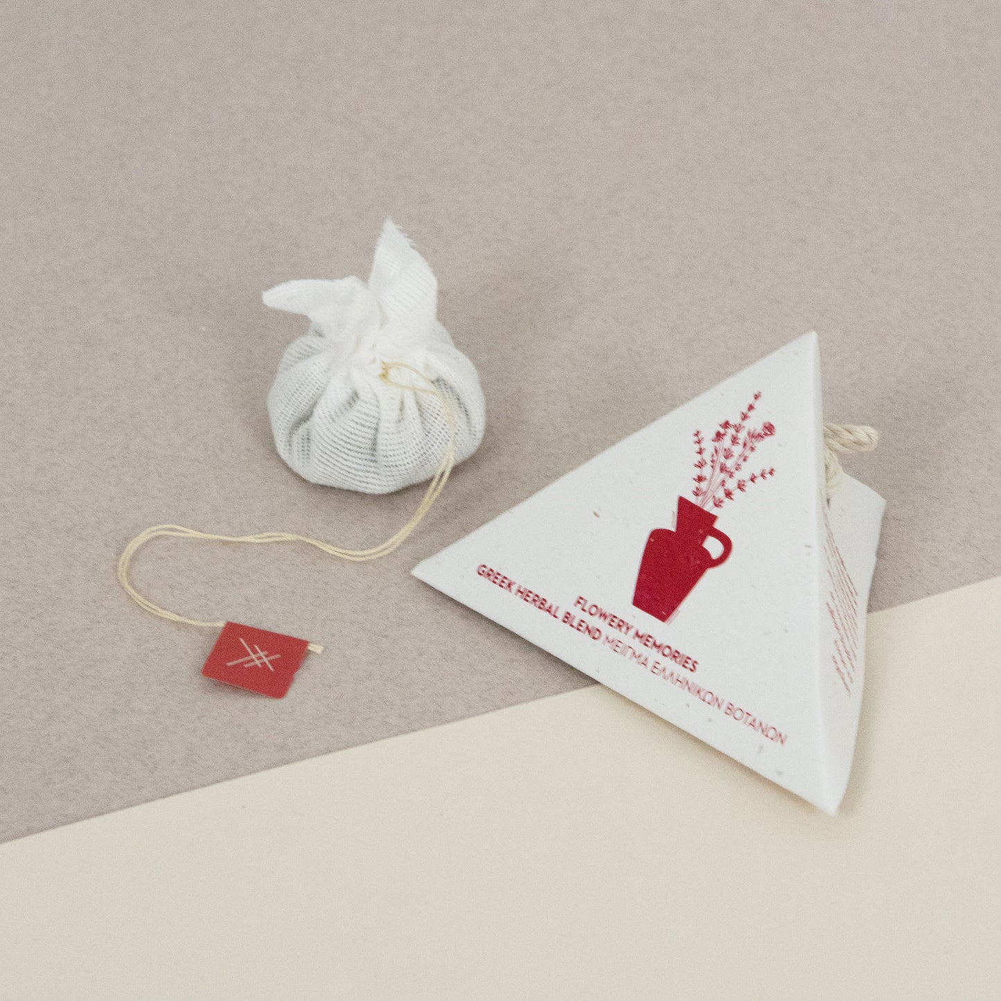 Tea bag and packaging of Flowery Memories by Arritos on a beige surface