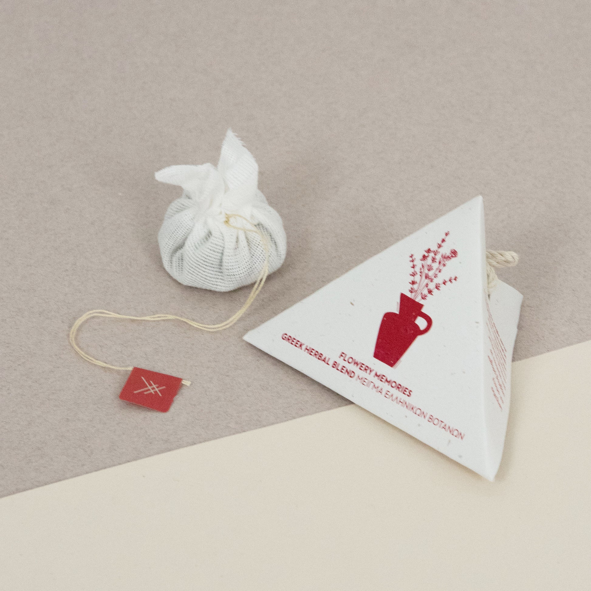 Tea bag and packaging of Flowery Memories by Arritos on a beige surface
