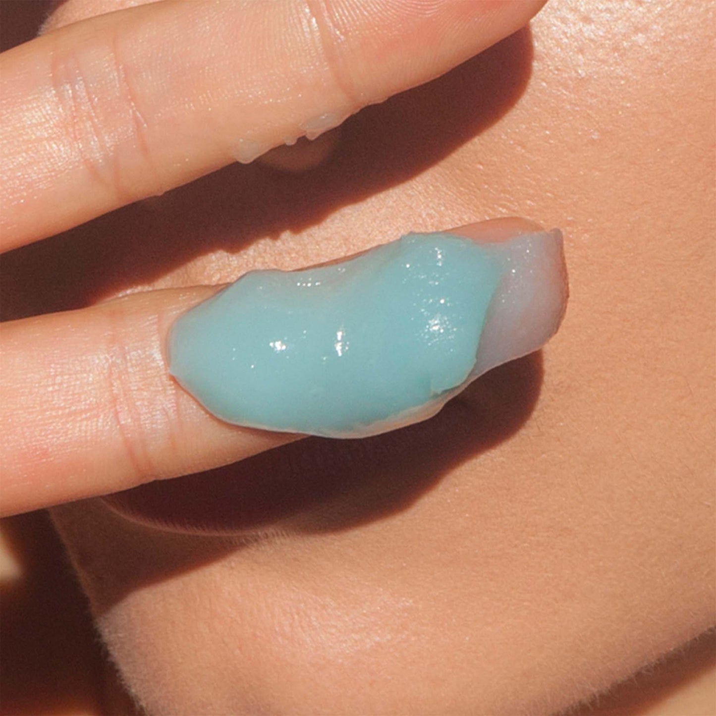 Close-up of a hand holding a small amount of le Blue Balm by Odacite
