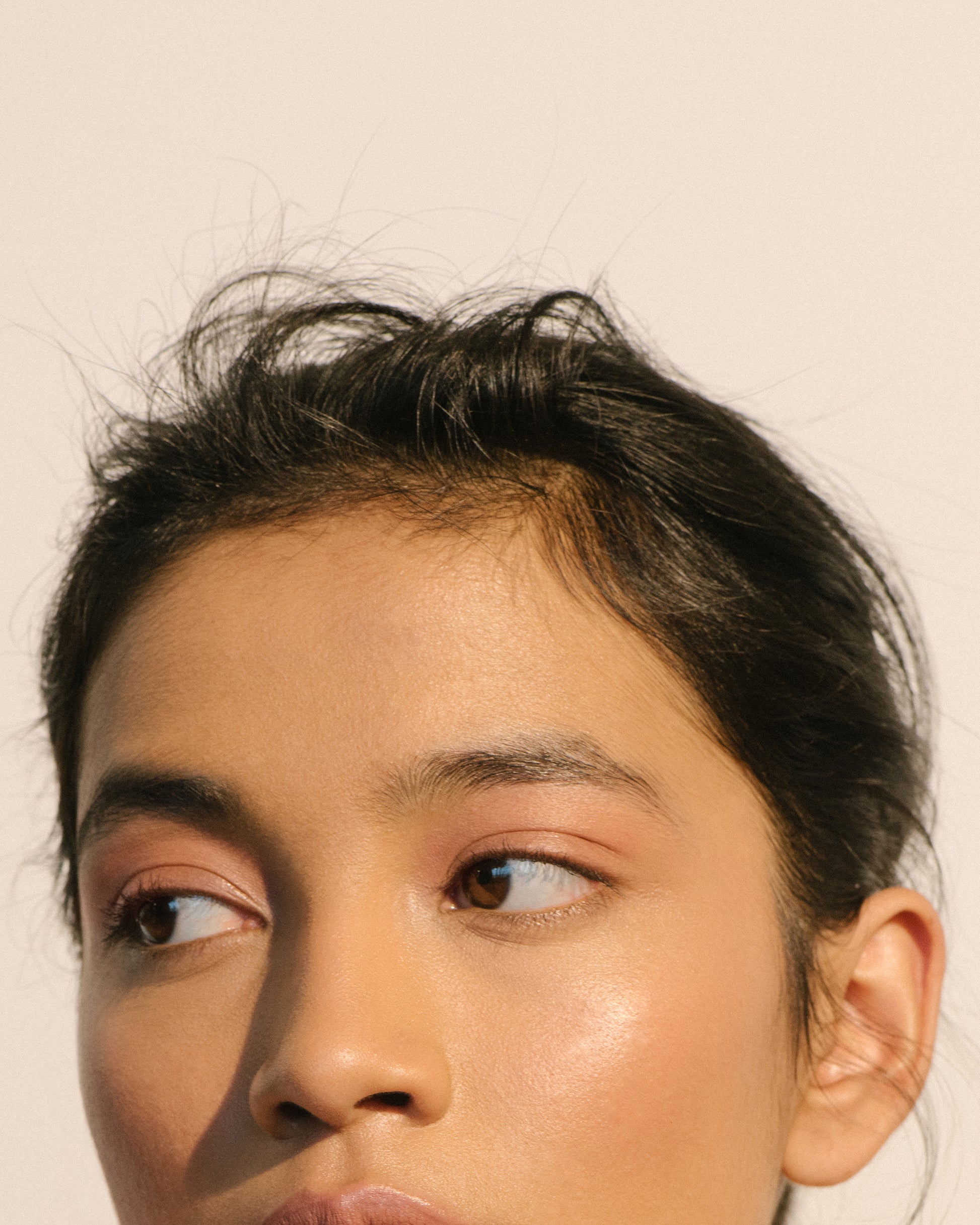 Close-up of a woman wearing the Manasi 7 Bisque All over Colour on her eyes, lips and cheeks with a neutral background