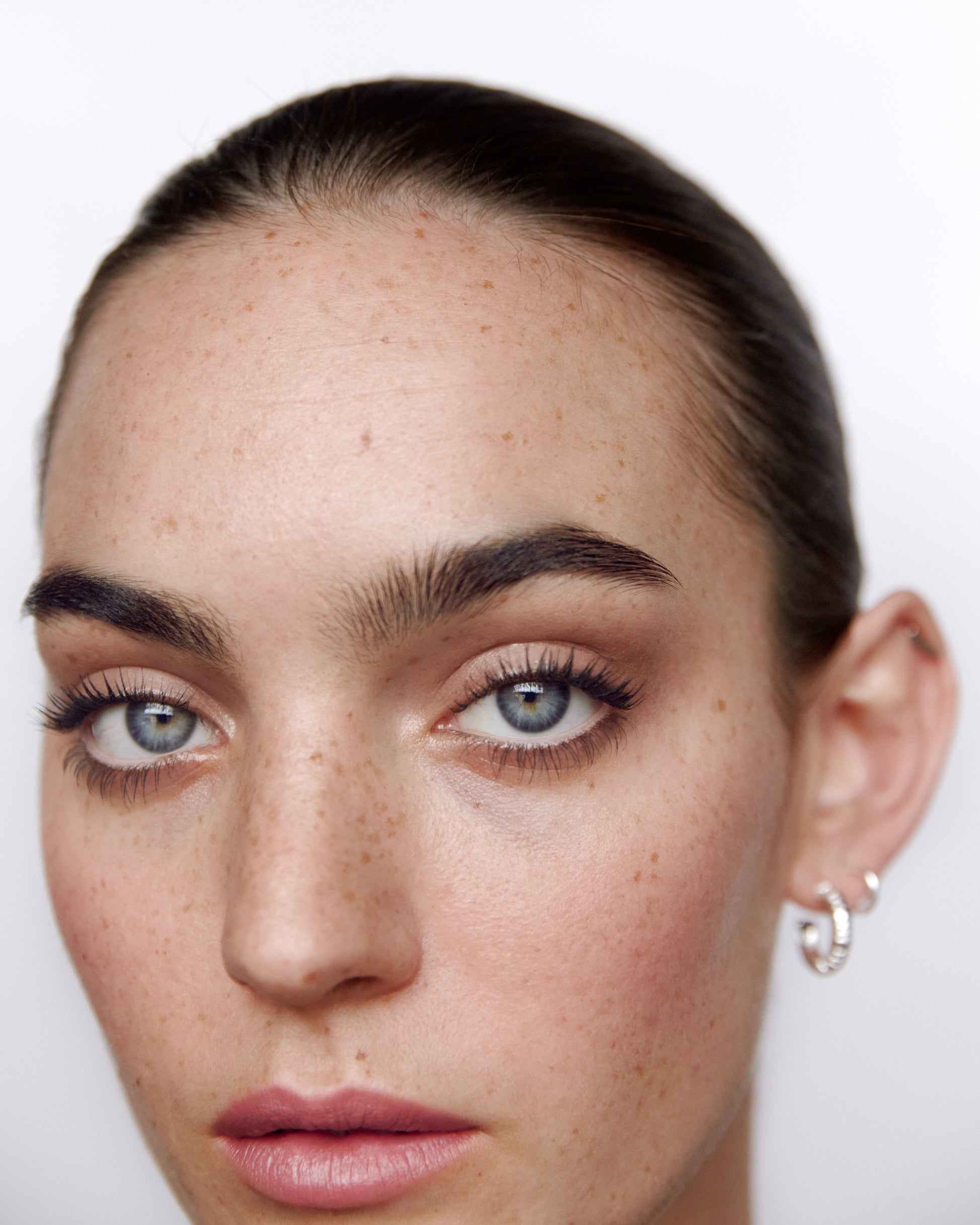 Close-up of a woman wearing the Manasi 7 Bisque All over Colour on her eyes, lips and cheeks with a neutral background
