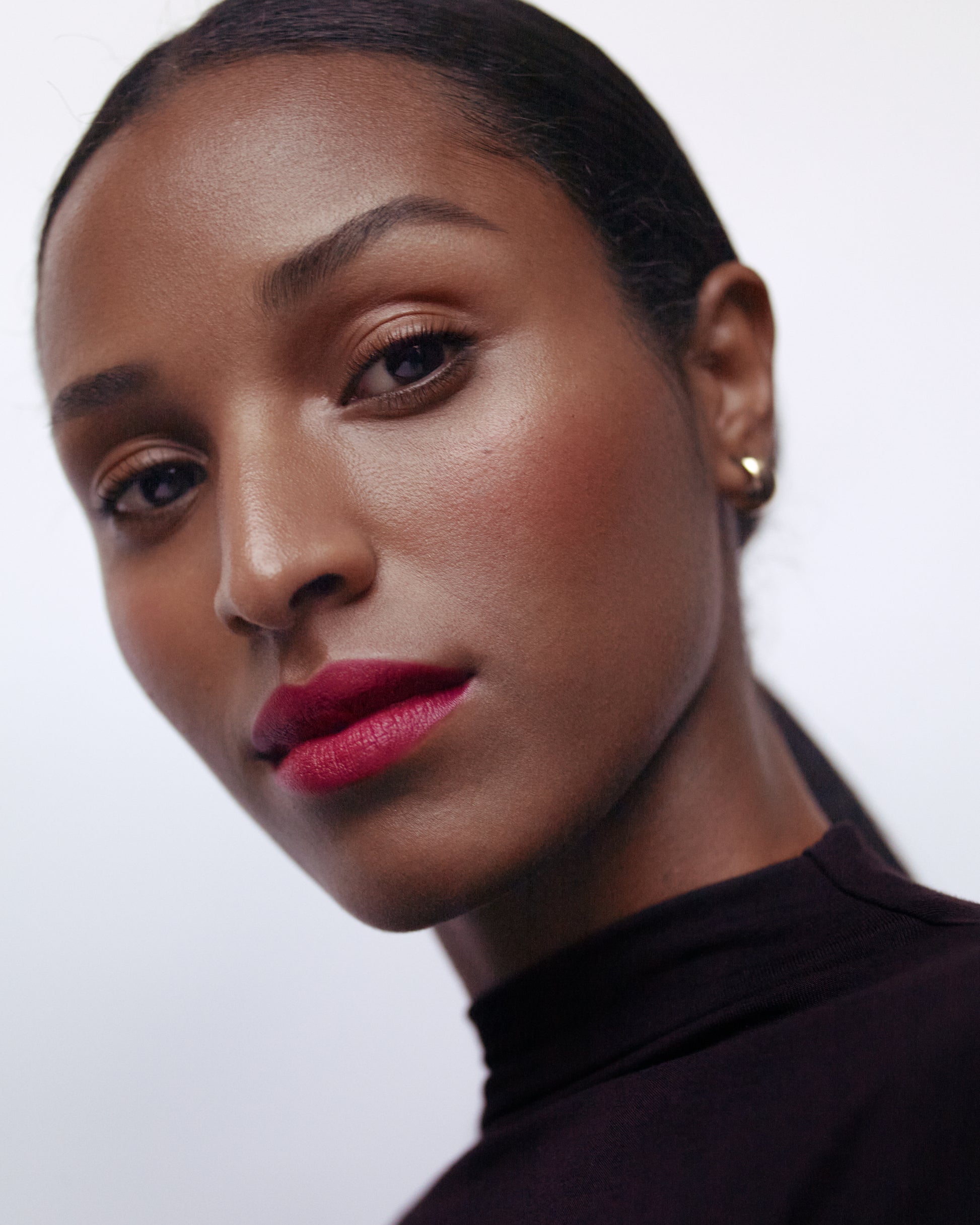 Close-up of a woman wearing the Manasi 7 Damaskino All over Colour on her eyes, lips and cheeks with a neutral background
