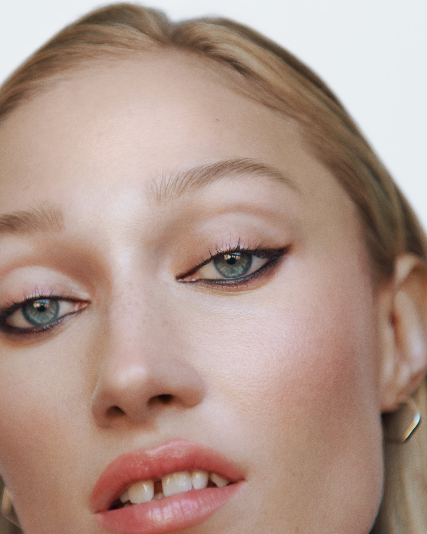 Close-up of a woman wearing the Manasi 7 Etruscan All over Colour on her eyes, lips and cheeks with a neutral background