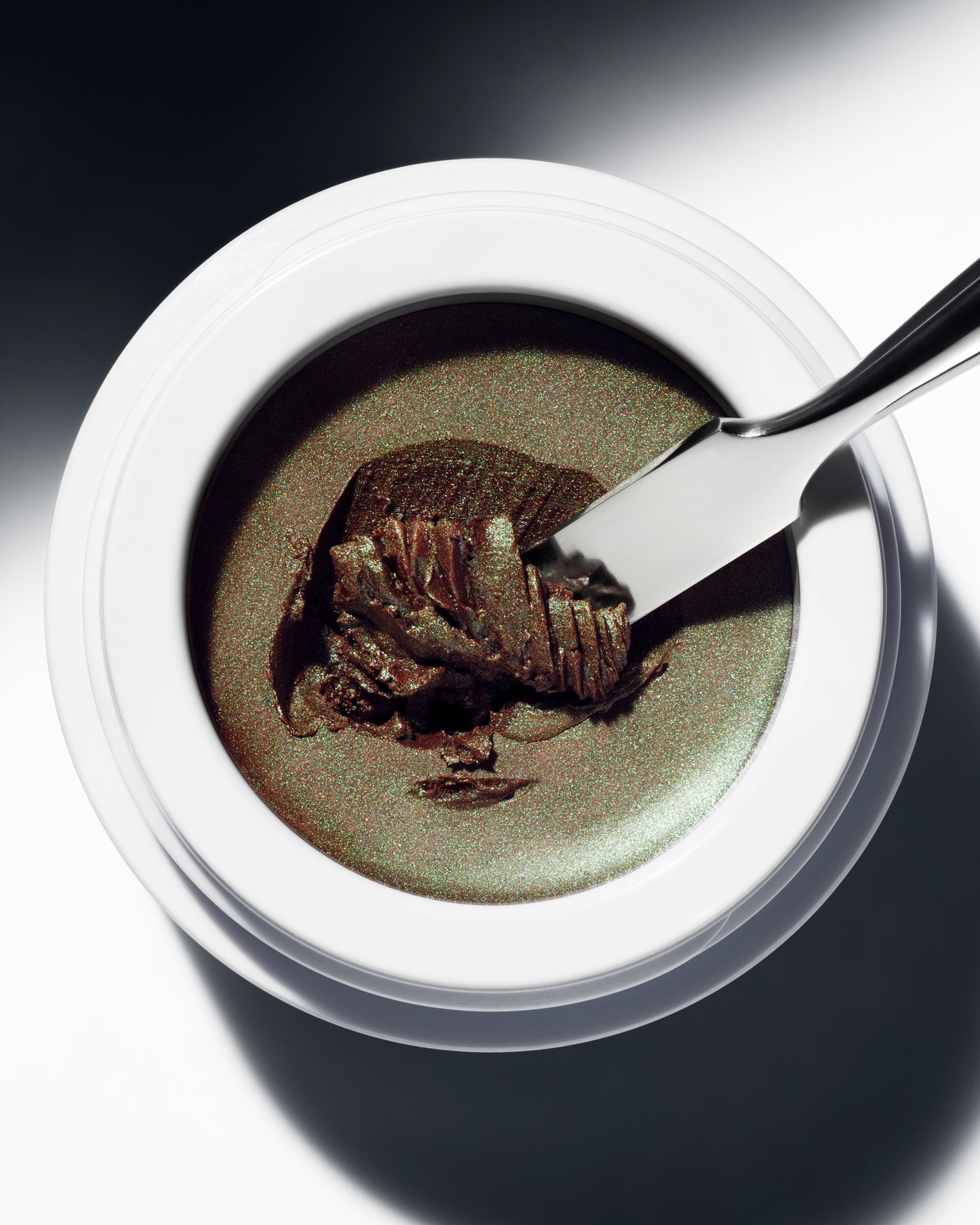 The Manasi 7 Eye Glow Colour in the shade Ochaya in a small round container on a white background