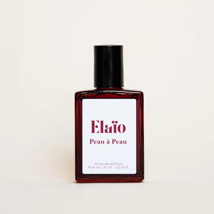 Perfume bottle labeled 'Elaio Peau à Peau' on a beige background