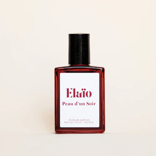 Perfume bottle labeled 'Elaïo Peau d'un Soir' on a beige background