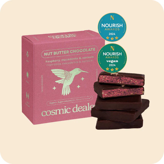 Box of Nut Butter Chocolate Raspberry  macadamia with 'Cosmic Dealer' branding and Nourish Awards badges on a beige background