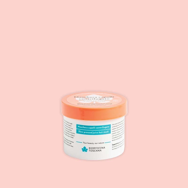 Jar of Slow-pressed juice hair mask by Biofficina Toscana with orange lid on a pink background