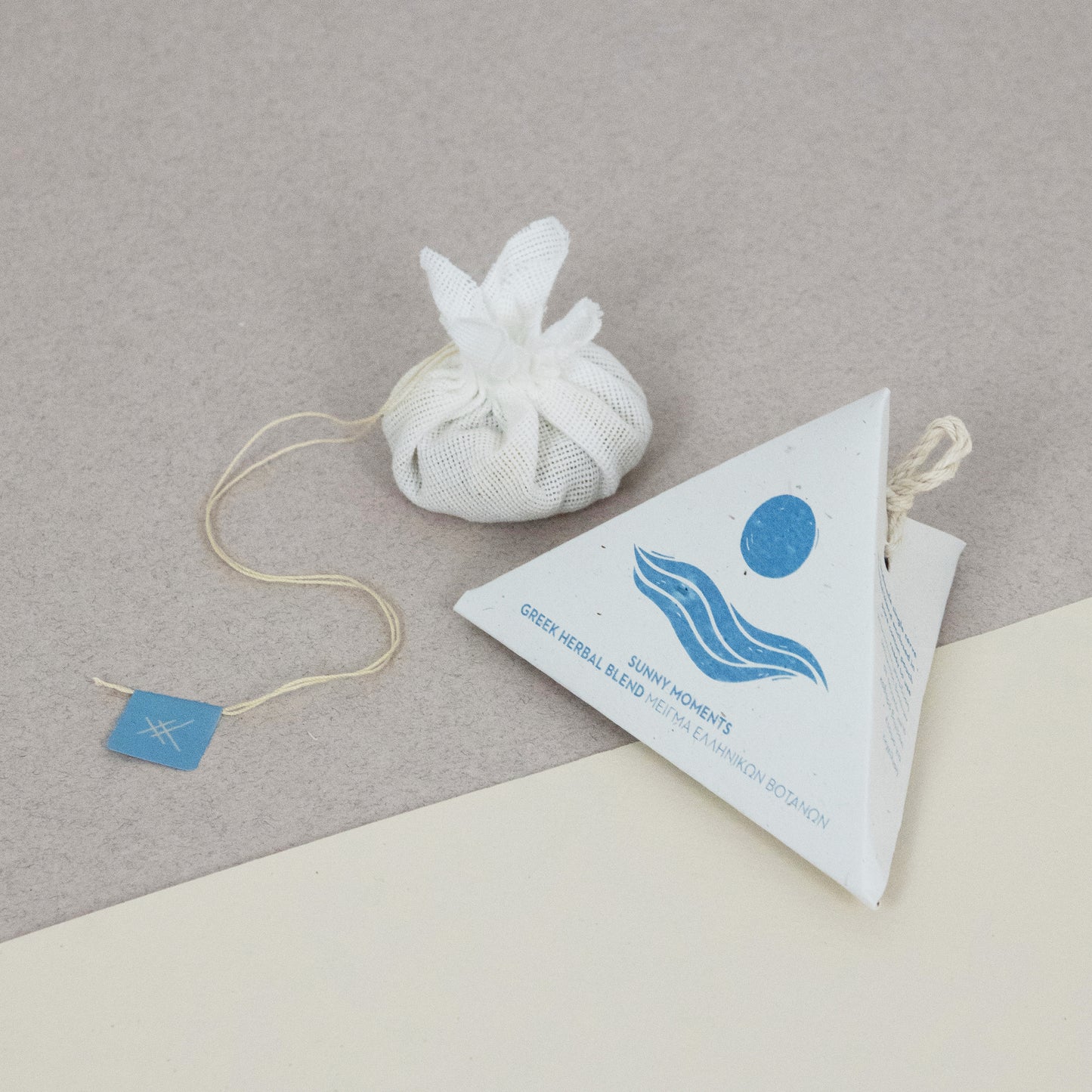 Cotton teabag with a triangular label of Sunny Moments by Arritos on a gray and beige background