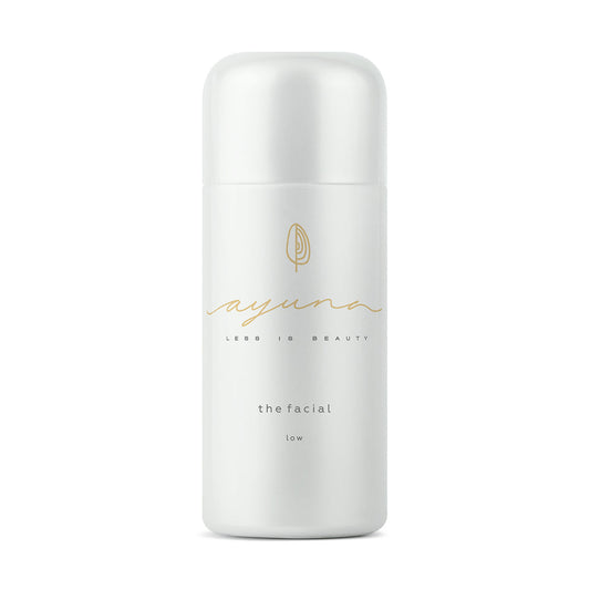 White skincare bottle of the facial - low by ayuna with gold text on a white background