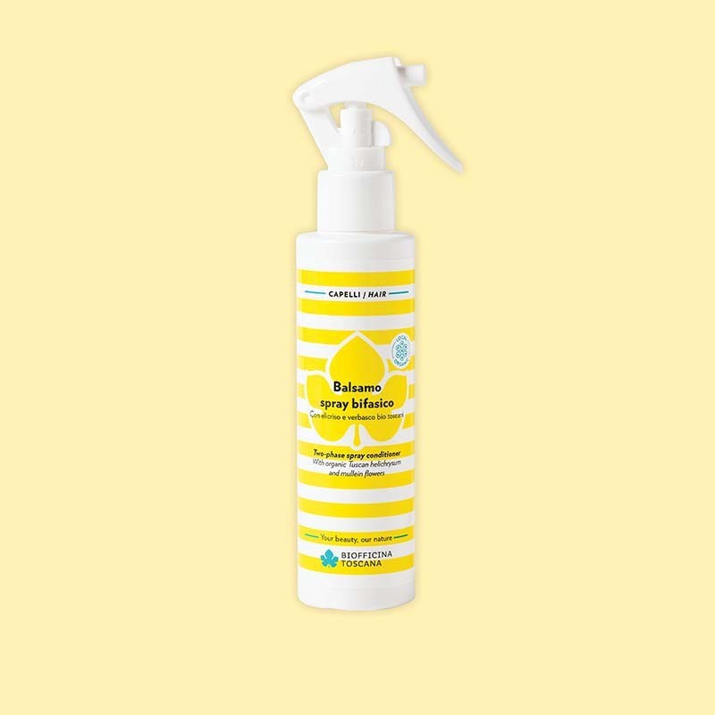 Spray bottle of the two phase spray conditioner by biofficina toscana with yellow label on a light yellow background