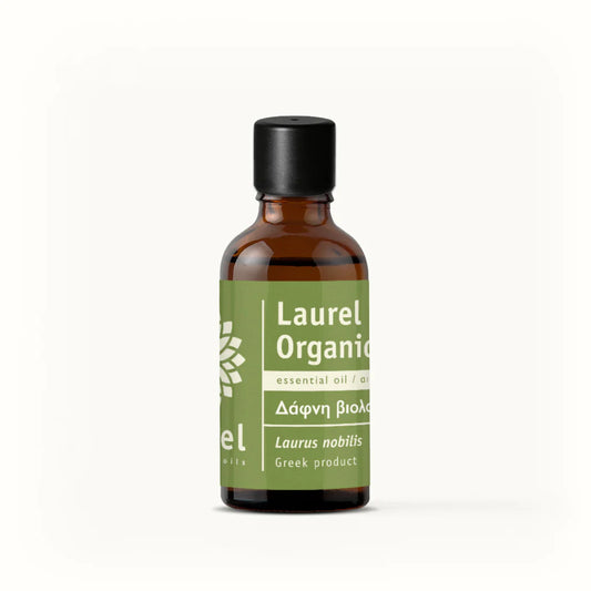 Bottle of Laurel Organic essential oil by vessel with a green label on a white background