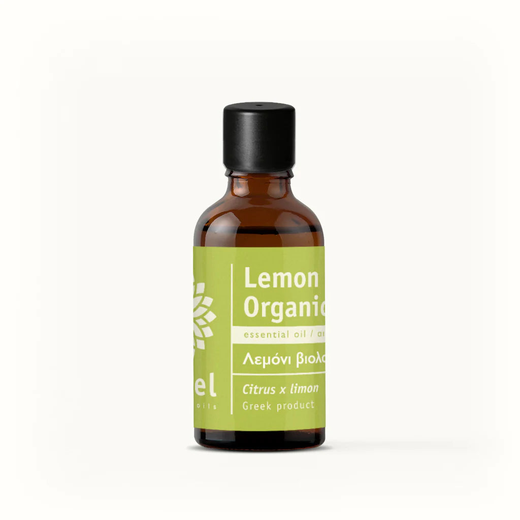 Bottle of lemon organic essential oil by vessel with a green label on a white background