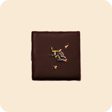 Square piece of Wild Lavender & Macadamia dark chocolate  on a beige background